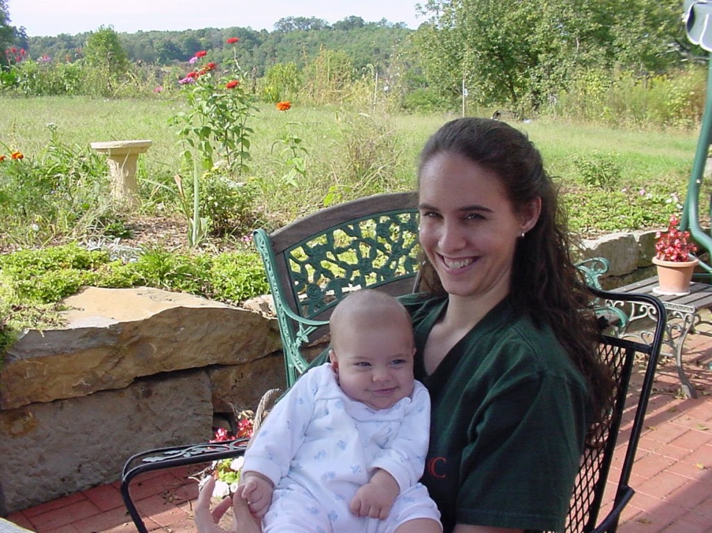 Mother holding a young child with a field background